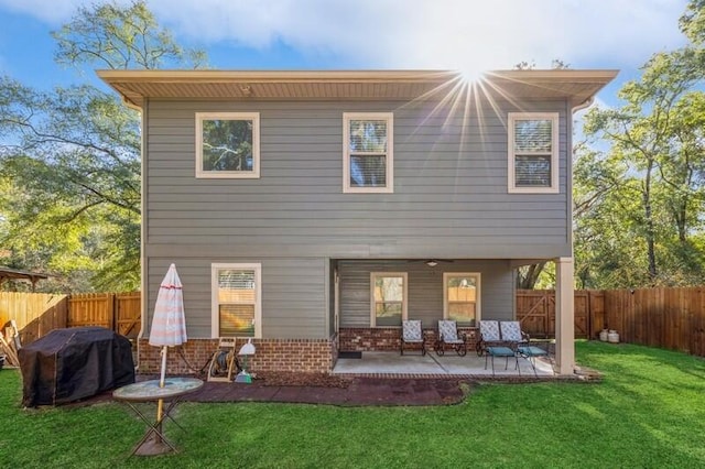 back of property with a yard and a patio area