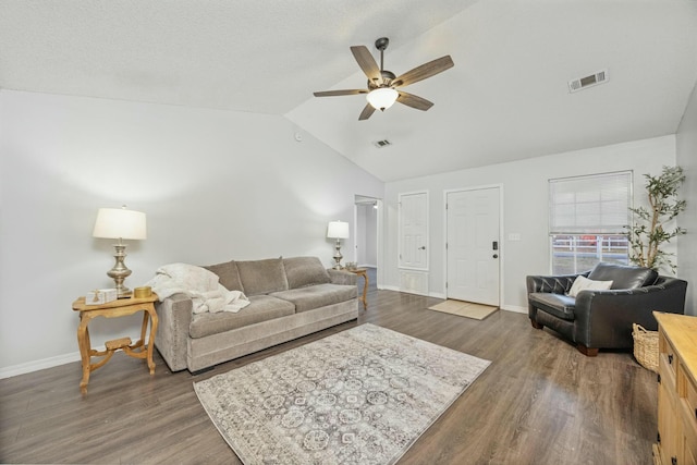 living room with ceiling fan, dark wood-type flooring, and vaulted ceiling