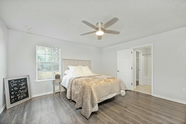 bedroom featuring hardwood / wood-style floors, a textured ceiling, ensuite bathroom, and ceiling fan