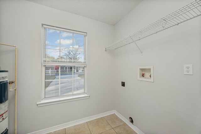 washroom with hookup for a washing machine, a textured ceiling, electric dryer hookup, and light tile patterned flooring