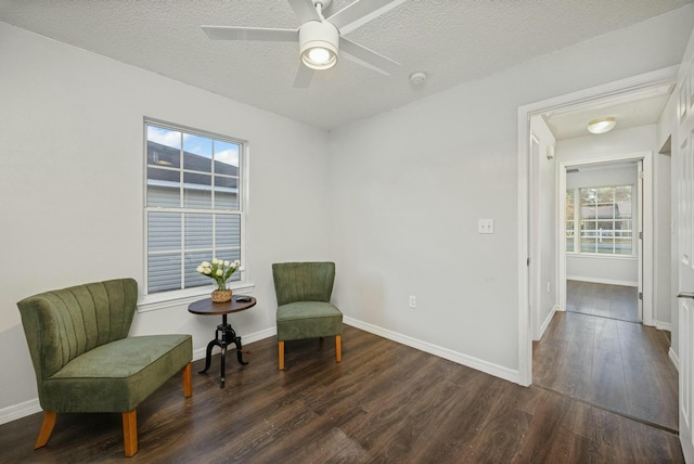 sitting room with ceiling fan, dark hardwood / wood-style flooring, a healthy amount of sunlight, and a textured ceiling