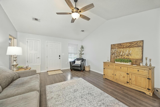 living room with dark hardwood / wood-style floors, ceiling fan, a textured ceiling, and vaulted ceiling