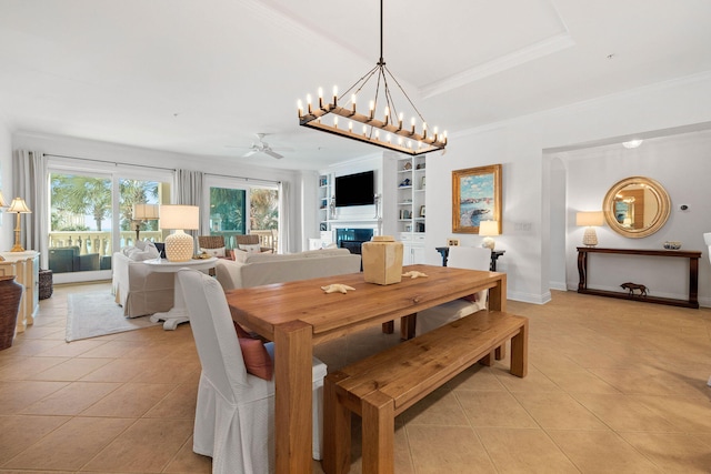 dining area with ceiling fan with notable chandelier, built in features, light tile patterned floors, and crown molding