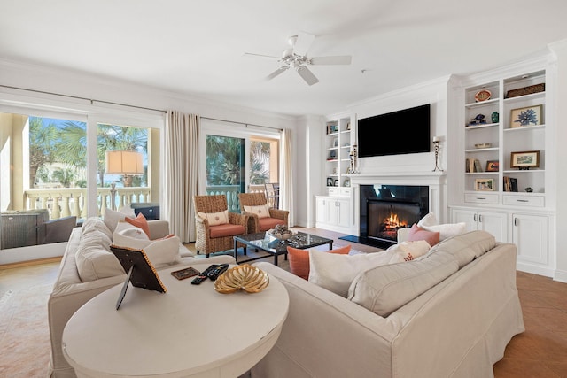 tiled living room featuring plenty of natural light, ceiling fan, and built in shelves