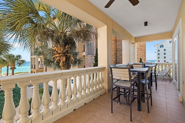 balcony featuring a water view and ceiling fan