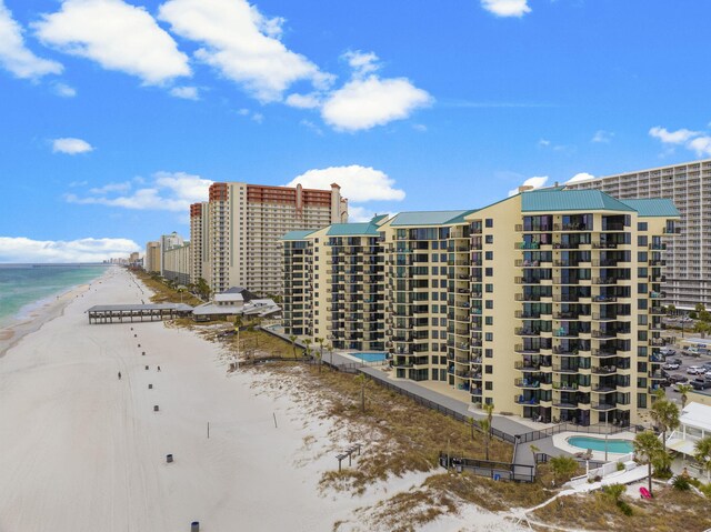 view of property with a water view and a beach view