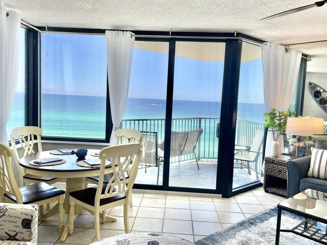 9850 S Thomas Dr Unit 1004W, Panama City Beach, FL 32408 - dining room featuring a textured ceiling, a water view, expansive windows, and light tile patterned flooring