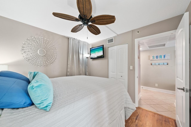 bedroom with ceiling fan, wood-type flooring, and a closet