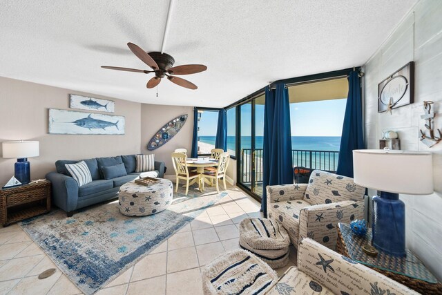 9850 S Thomas Dr Unit 1004W, Panama City Beach, FL 32408 - tiled living room featuring a water view, a ceiling fan, a textured ceiling, and a wall of windows