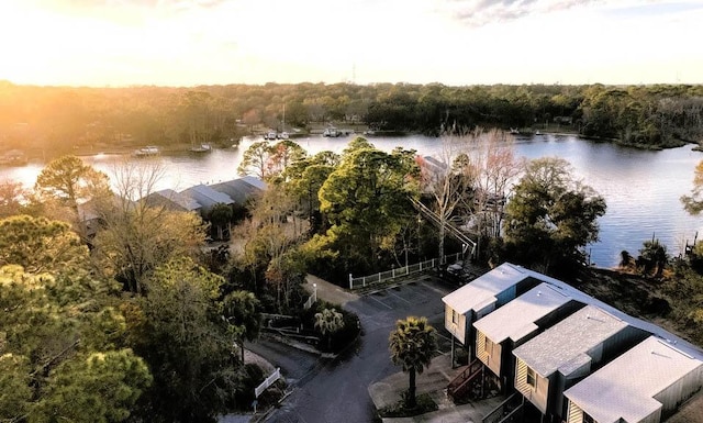 aerial view at dusk featuring a water view