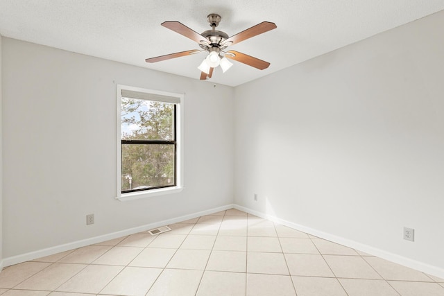 unfurnished room featuring light tile patterned floors, baseboards, visible vents, a ceiling fan, and a textured ceiling