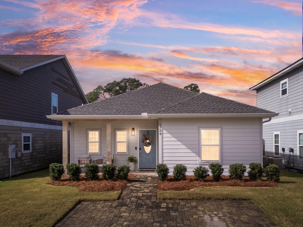 view of front of property featuring a lawn and central AC unit