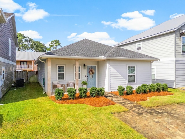 view of front of house with a front yard, central AC, and covered porch