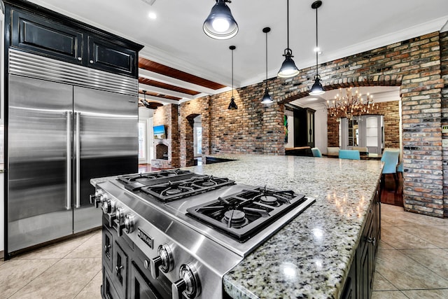 kitchen with brick wall, stainless steel appliances, pendant lighting, beamed ceiling, and light tile patterned flooring