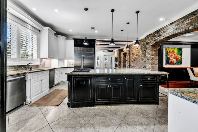 kitchen featuring ceiling fan, white cabinetry, a kitchen island, and appliances with stainless steel finishes