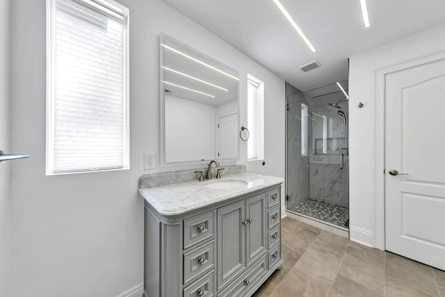 bathroom featuring a shower with door, vanity, and tile patterned flooring