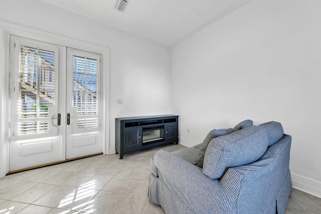 living area with light tile patterned flooring and french doors