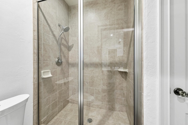 bathroom featuring an enclosed shower and toilet