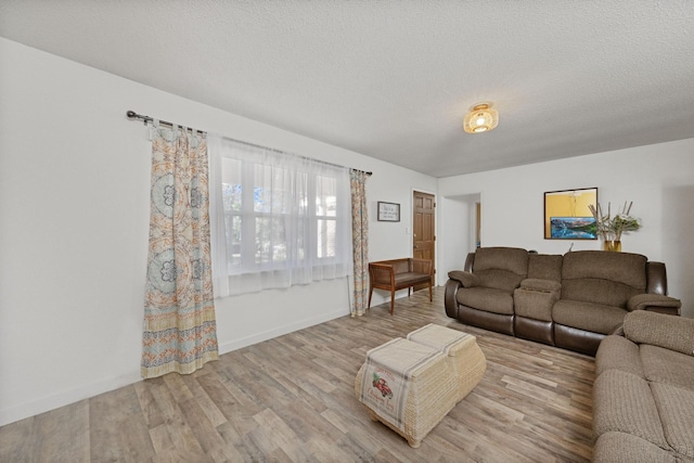 living room with a textured ceiling and light hardwood / wood-style floors