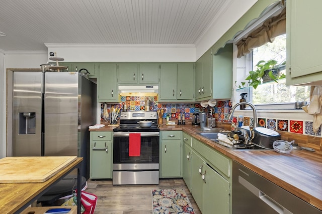 kitchen featuring butcher block countertops, crown molding, stainless steel appliances, and green cabinetry