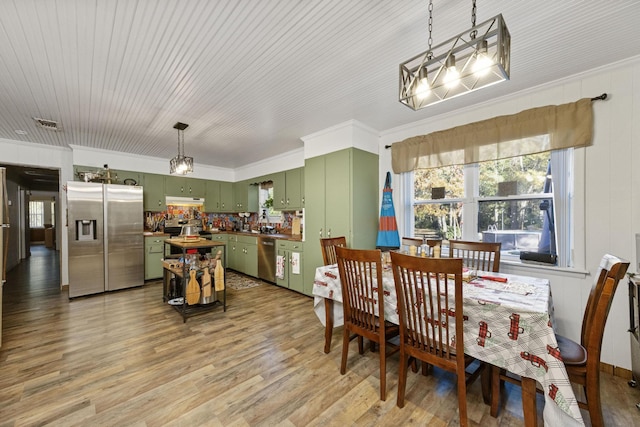 dining room with light hardwood / wood-style floors and ornamental molding