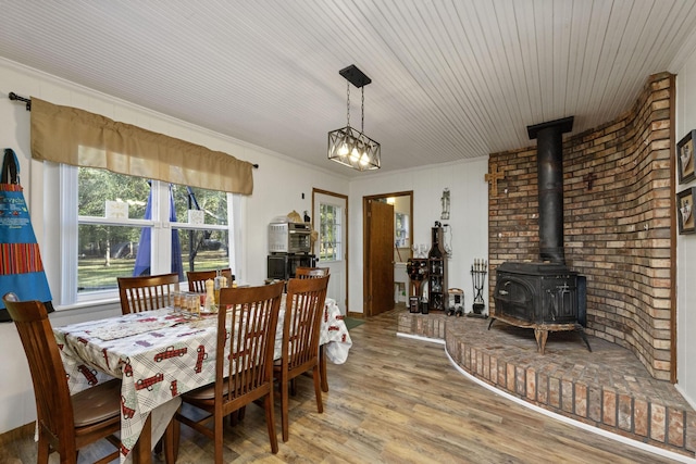 dining area featuring a wood stove, hardwood / wood-style floors, and ornamental molding