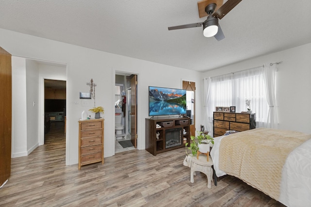 bedroom featuring hardwood / wood-style flooring, ceiling fan, a textured ceiling, and connected bathroom