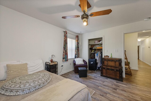 bedroom with ceiling fan, wood-type flooring, and a closet