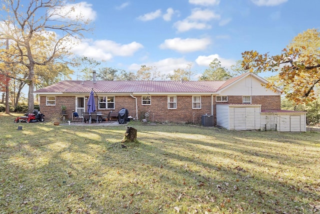 rear view of property featuring a lawn, a patio area, and central AC