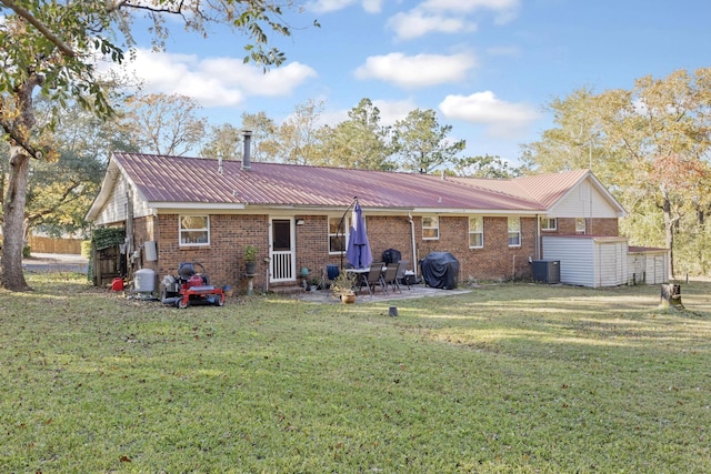 back of property with a patio area, a yard, and central AC