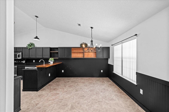 kitchen featuring decorative light fixtures, electric stove, a chandelier, and vaulted ceiling