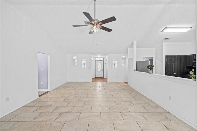 unfurnished living room with ceiling fan, light tile patterned floors, and a textured ceiling