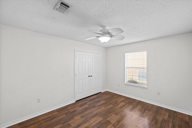 unfurnished room featuring a textured ceiling, dark hardwood / wood-style flooring, and ceiling fan