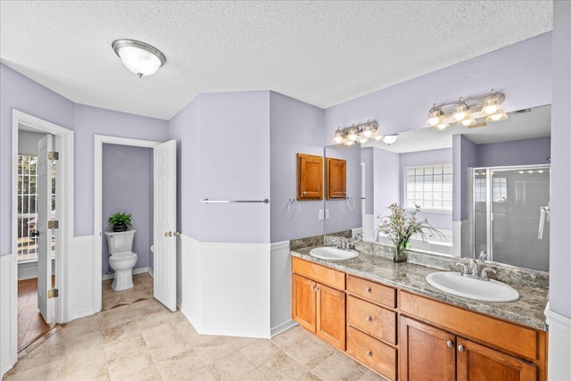 full bathroom featuring vanity, a textured ceiling, and toilet