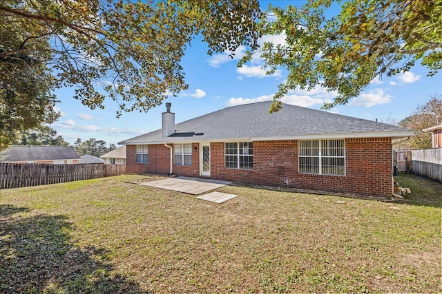 rear view of house featuring a lawn and a patio area