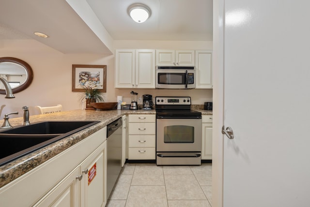 kitchen with sink, light tile patterned floors, and appliances with stainless steel finishes