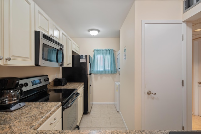 kitchen featuring white cabinets, light stone countertops, light tile patterned floors, and stainless steel appliances