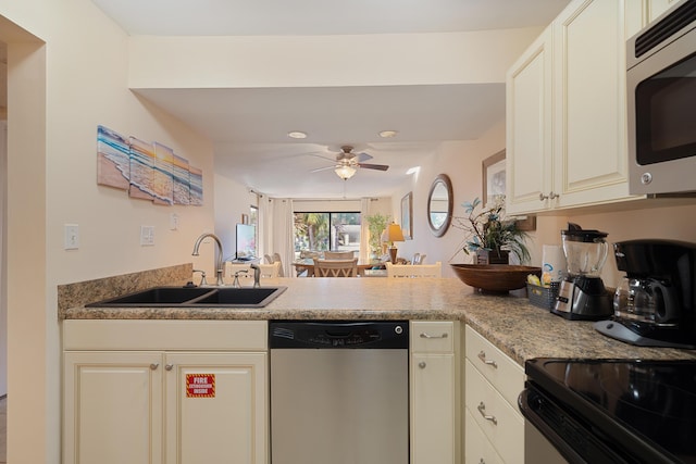 kitchen with ceiling fan, sink, light stone counters, cream cabinets, and appliances with stainless steel finishes