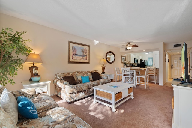 living room featuring carpet and ceiling fan