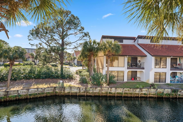 back of property featuring a balcony and a water view