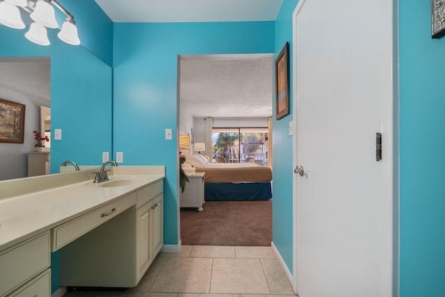 bathroom featuring tile patterned flooring, vanity, and a textured ceiling