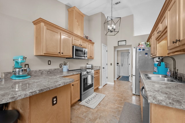 kitchen with pendant lighting, an inviting chandelier, sink, a towering ceiling, and appliances with stainless steel finishes