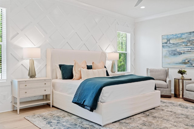 bedroom featuring crown molding, light hardwood / wood-style flooring, and ceiling fan