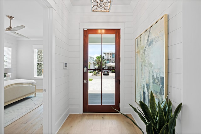 doorway to outside with light hardwood / wood-style flooring and ceiling fan