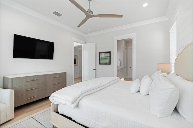 bedroom featuring ceiling fan, ornamental molding, light hardwood / wood-style flooring, and ensuite bath