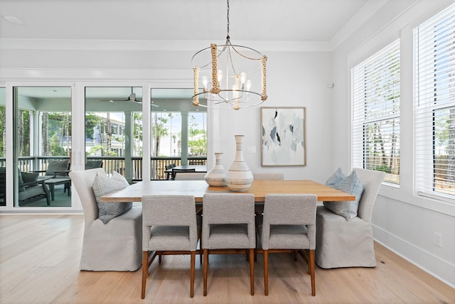 dining area featuring an inviting chandelier, a wealth of natural light, and light hardwood / wood-style flooring