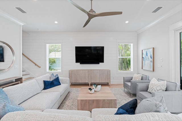 living room featuring ceiling fan, light hardwood / wood-style flooring, and crown molding