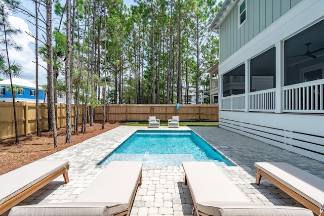 view of pool featuring pool water feature, a sunroom, and a patio area