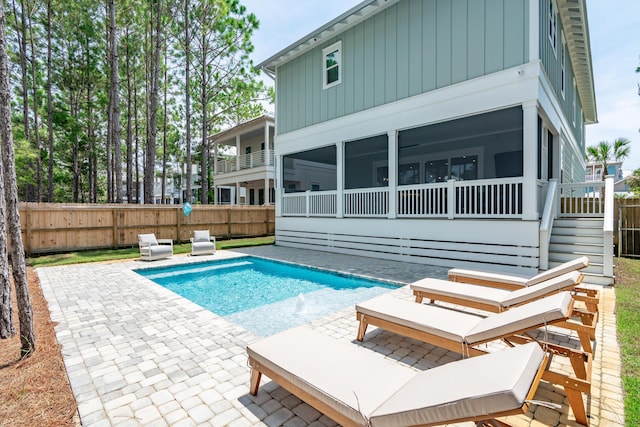 view of swimming pool featuring a sunroom and a patio area