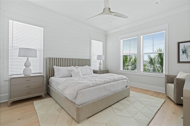 bedroom with light wood-type flooring, ceiling fan, and ornamental molding